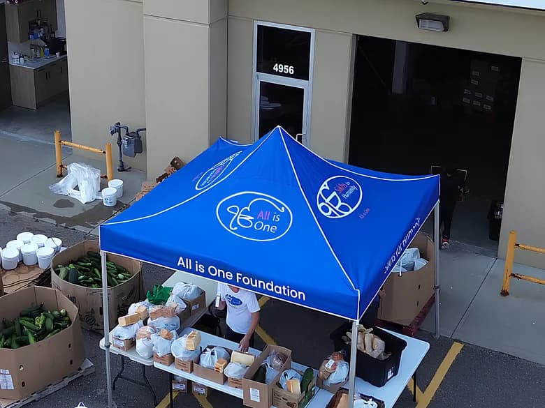 The All is One Foundation tent from above, set up with produce outside 4956 Roper Road